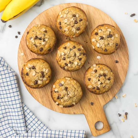 Gluten Free Banana Chocolate Chip Muffins on a circular wooden platter